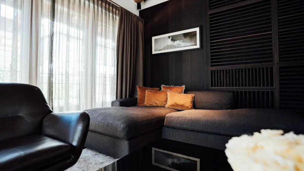 Sofa corner with leather armchair and light-flooded windows