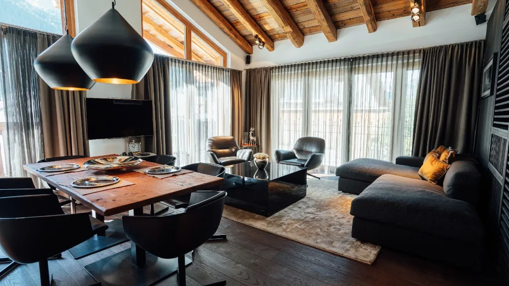 Dining area with a laid table, sofa and wooden slat wall in the background