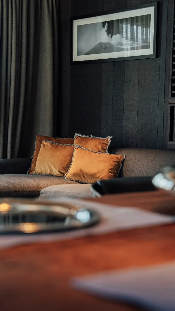 Sofa with velvet cushions, the laid dining table in the foreground