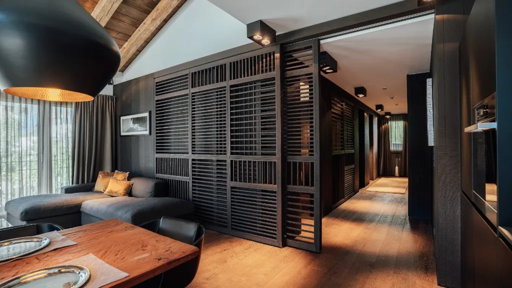 Living area with wooden slat sliding door and view into the hallway