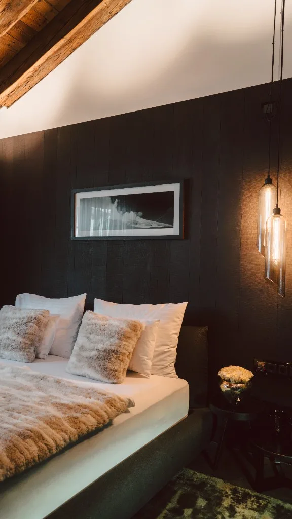 Bedroom under the sloping roof with fur throw and pendant lights