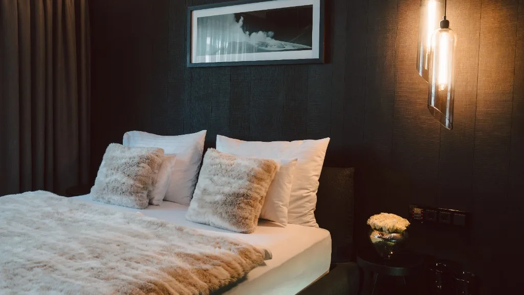 Bedroom with fur throw, cushions and glass lights