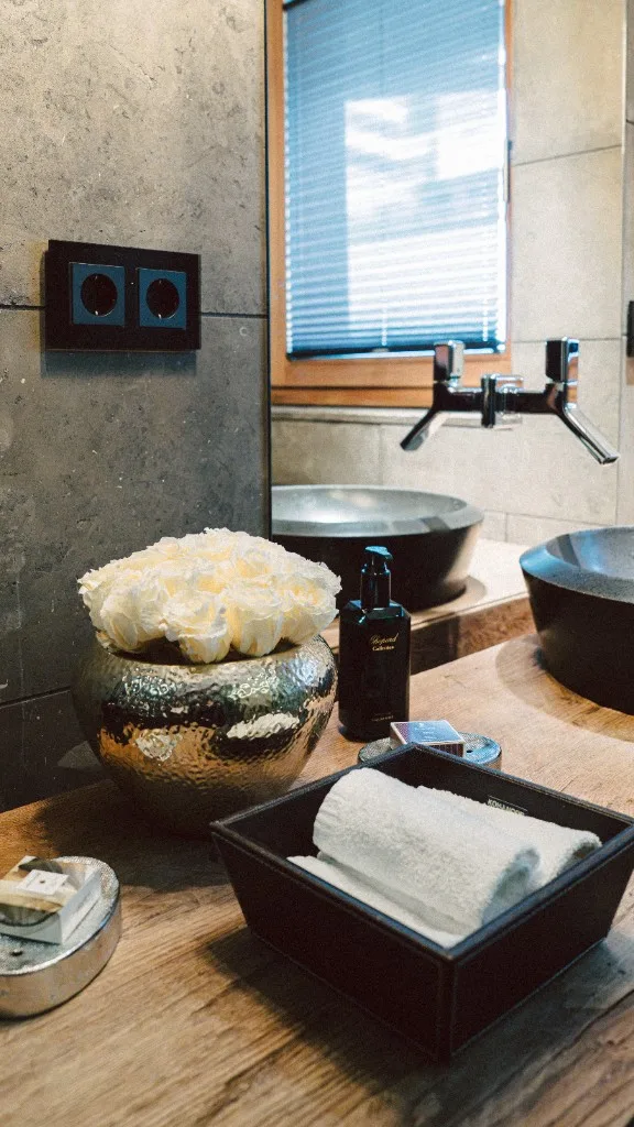Washstand with roses, care products and rolled towels