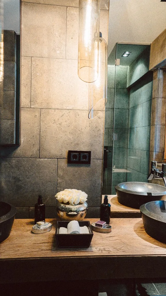 Bathroom with glass pendant light and view into the shower