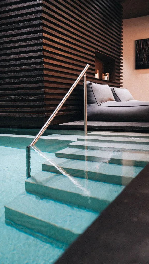Steps into the pool with a stainless steel handrail